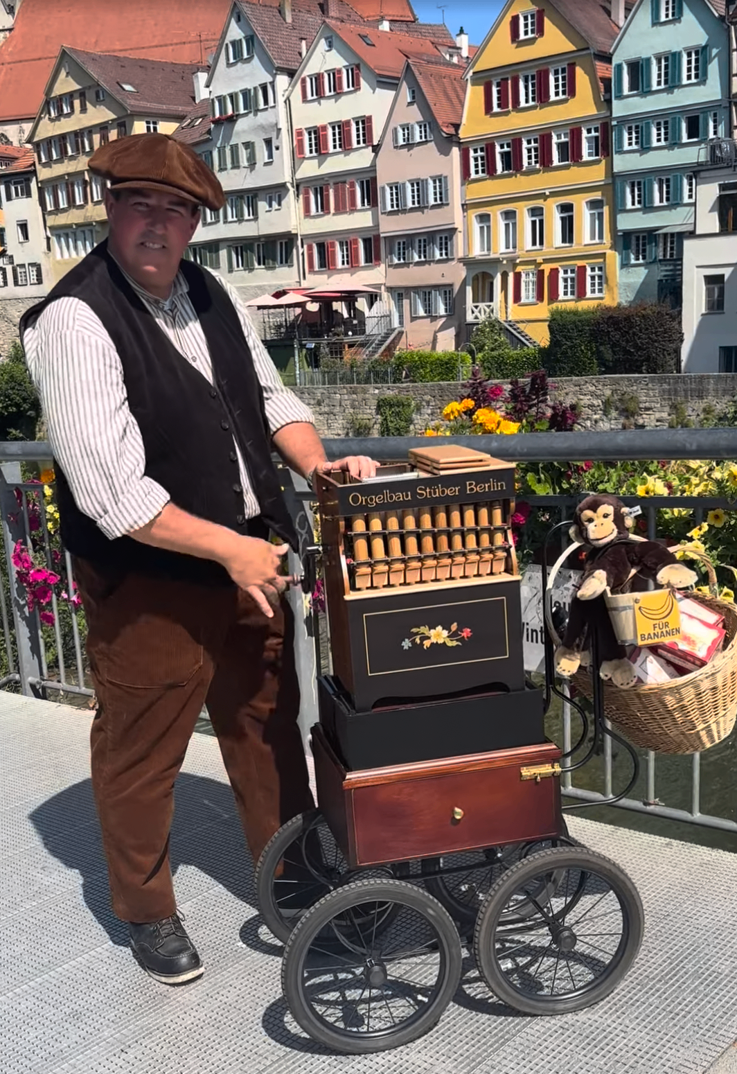 Drehorgel von Leierkasten Joe vor der bunten Neckarfront in Tübingen, mit Steiff-Affe und Spendendose "Für Bananen"