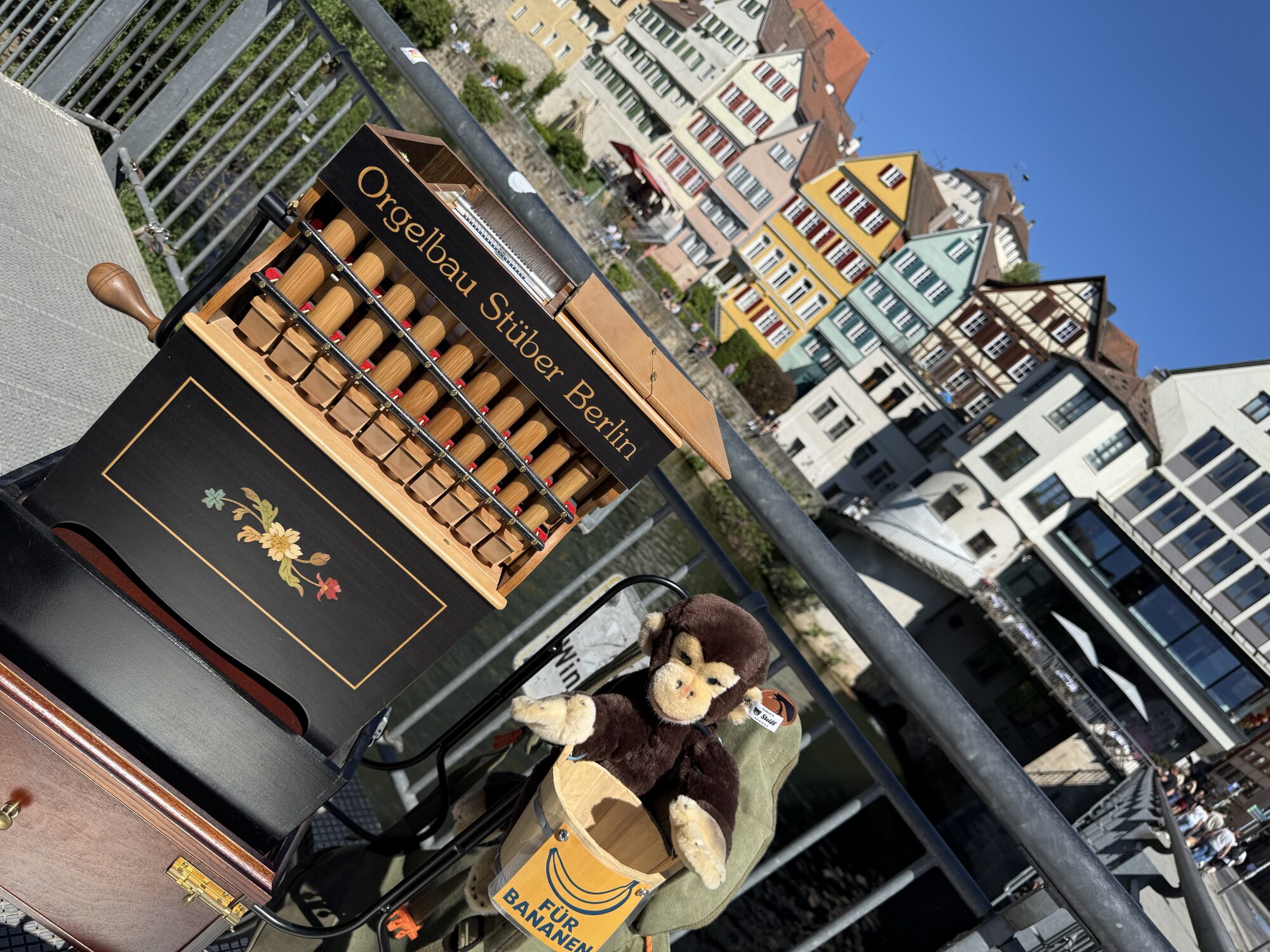 Drehorgelspieler in traditioneller Kleidung bei einem Stadtfest mit Fachwerkhäusern